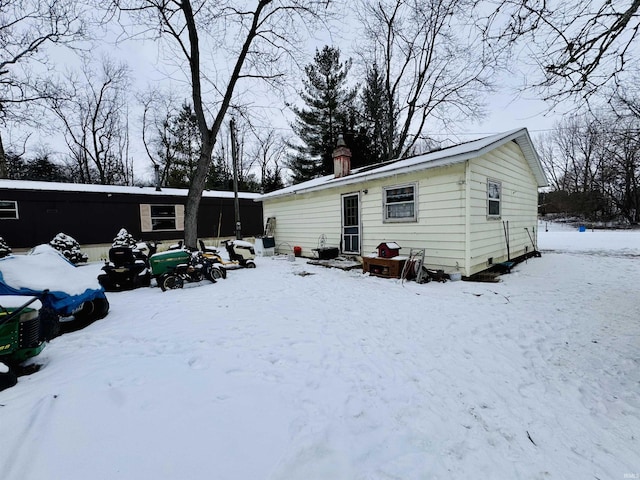 view of snow covered back of property