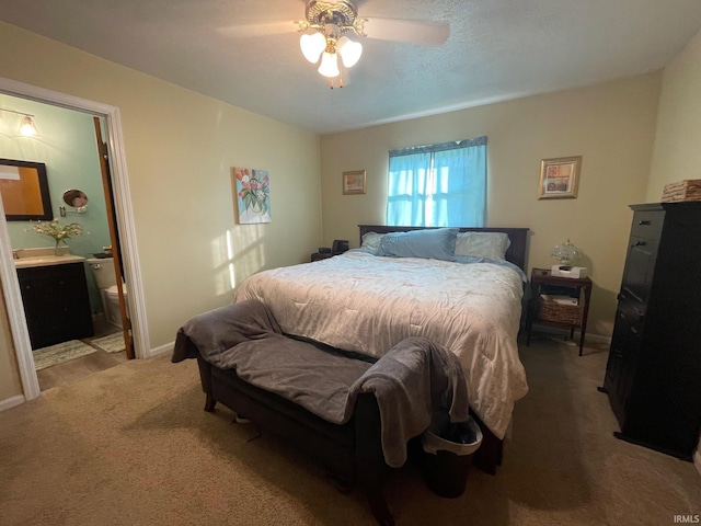 carpeted bedroom featuring ceiling fan and connected bathroom