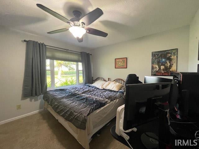 bedroom featuring ceiling fan and carpet