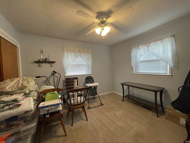 living area with ceiling fan and carpet flooring