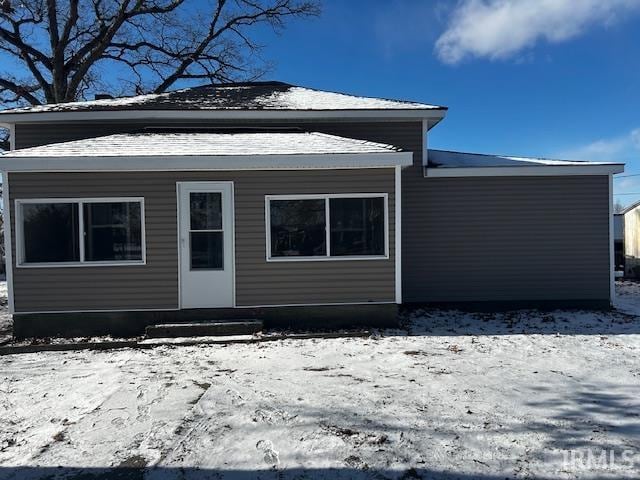 view of snow covered rear of property