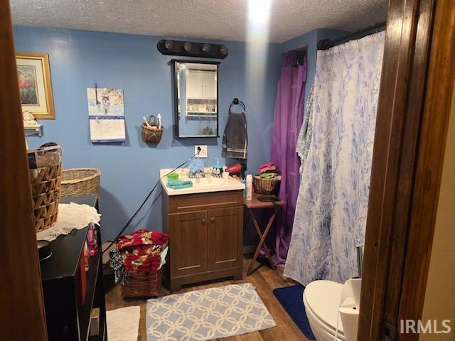 bathroom with vanity, hardwood / wood-style floors, a textured ceiling, and toilet