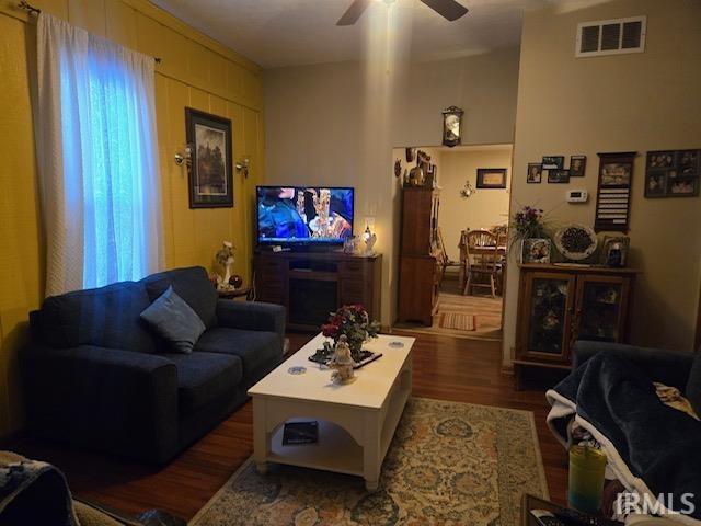 living room featuring dark hardwood / wood-style flooring and ceiling fan