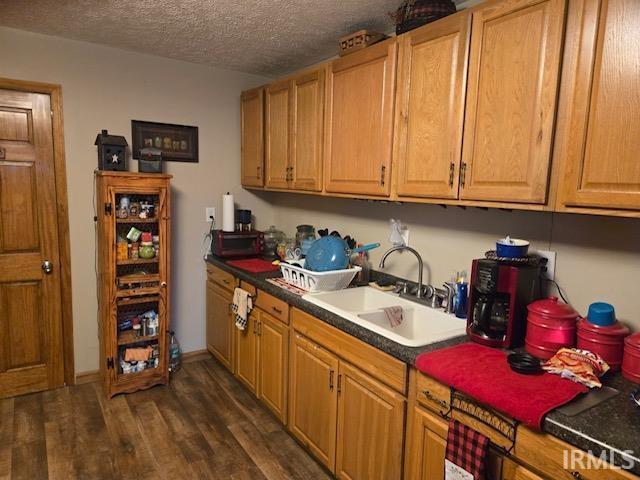 kitchen with dark hardwood / wood-style floors, sink, and a textured ceiling