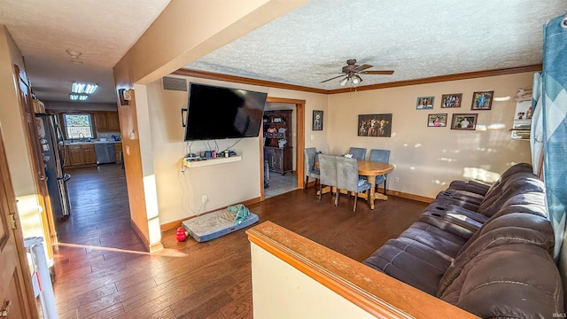 living room featuring ceiling fan, a textured ceiling, dark hardwood / wood-style flooring, and ornamental molding