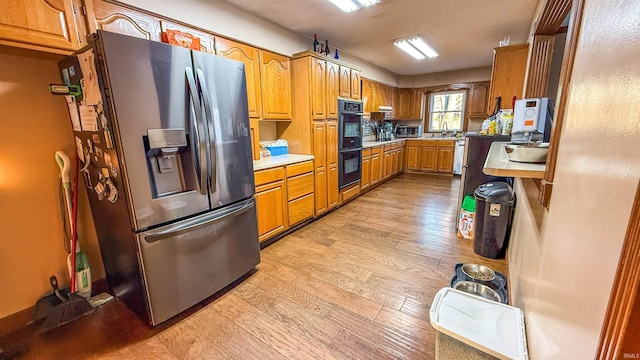 kitchen featuring stainless steel appliances, light hardwood / wood-style flooring, and sink