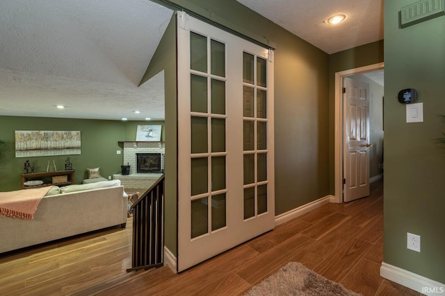 hallway featuring hardwood / wood-style flooring and a textured ceiling