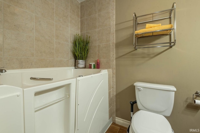 bathroom with toilet and a washtub