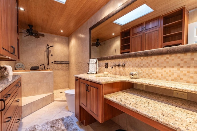 bathroom featuring wooden ceiling, a skylight, vanity, and ceiling fan