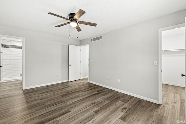 empty room with ceiling fan and dark hardwood / wood-style floors