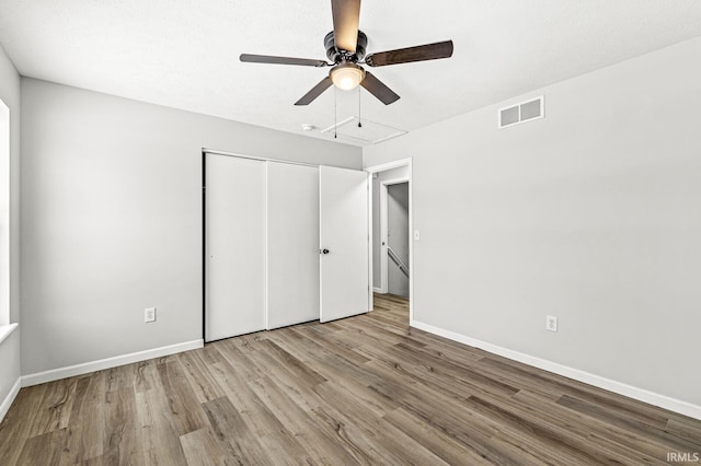 unfurnished bedroom with ceiling fan, a closet, and light hardwood / wood-style floors