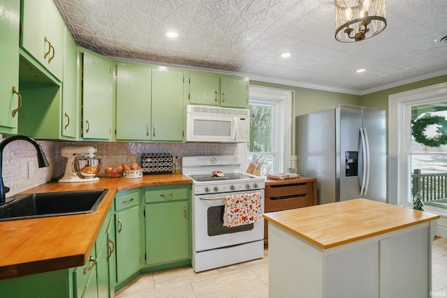 kitchen with sink, white appliances, green cabinets, and butcher block countertops