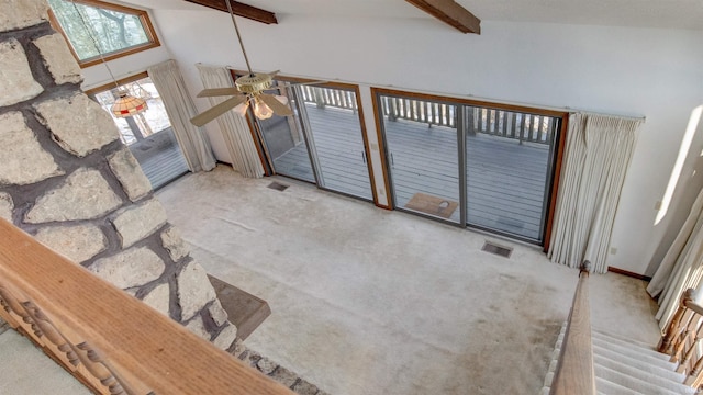 unfurnished living room with ceiling fan, light carpet, beamed ceiling, and high vaulted ceiling