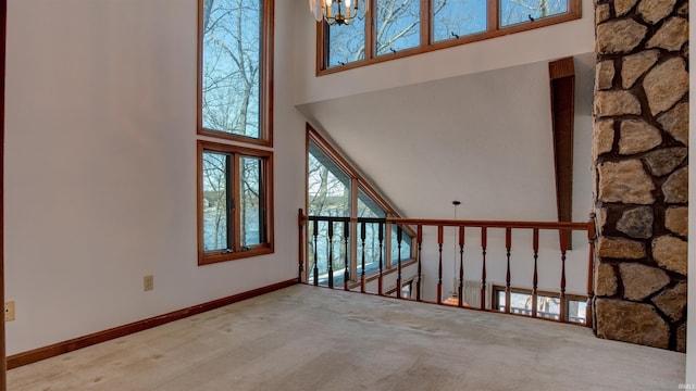 interior space with carpet, a towering ceiling, and an inviting chandelier