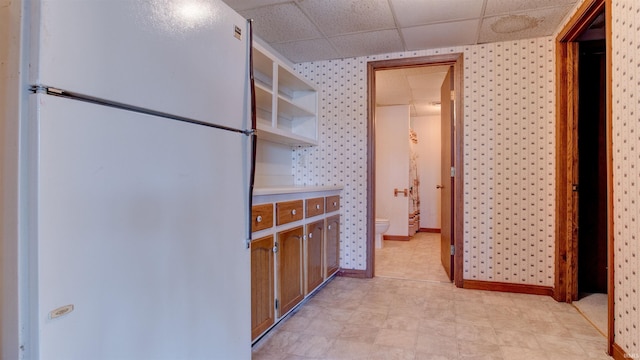 kitchen with a drop ceiling and white refrigerator