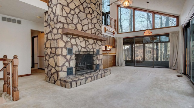 unfurnished living room with a high ceiling, light carpet, and a stone fireplace