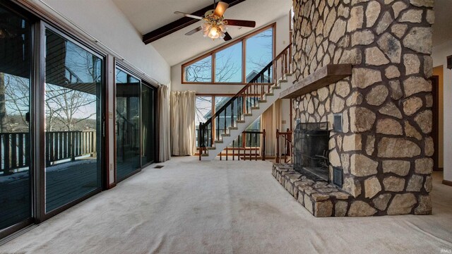 unfurnished living room with carpet floors, a fireplace, ceiling fan, high vaulted ceiling, and beam ceiling