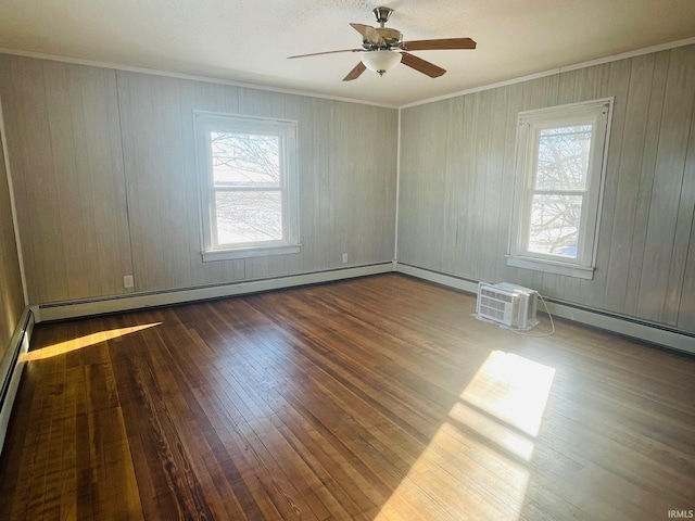 spare room featuring ceiling fan, ornamental molding, a healthy amount of sunlight, and dark hardwood / wood-style floors