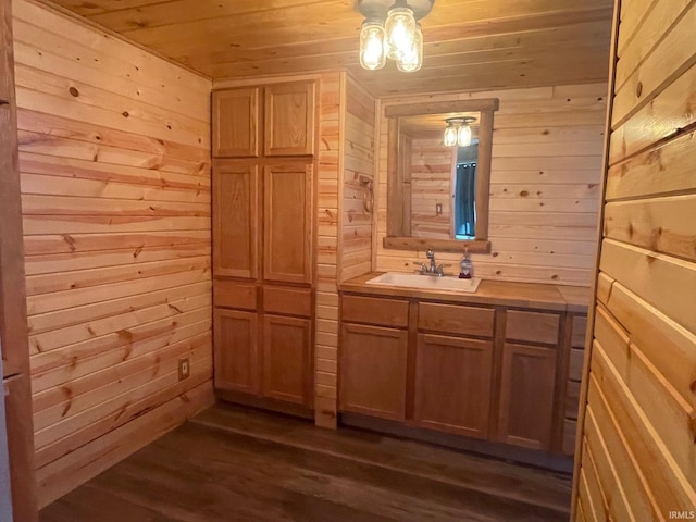 bathroom with hardwood / wood-style flooring, wooden ceiling, vanity, and wood walls