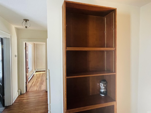 interior space with hardwood / wood-style floors and a baseboard heating unit