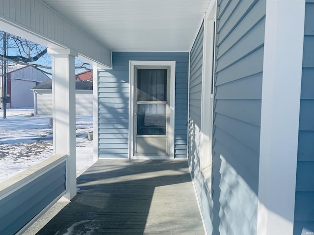 view of snow covered back of property