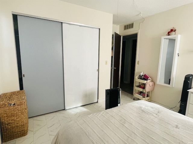 bedroom featuring a textured ceiling and a closet