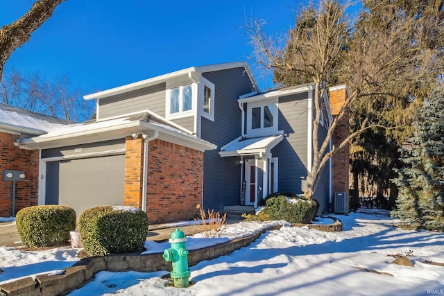 view of front of property featuring a garage and cooling unit