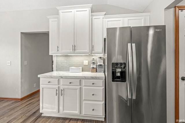 kitchen featuring white cabinets, stainless steel refrigerator with ice dispenser, dark wood-type flooring, tasteful backsplash, and vaulted ceiling