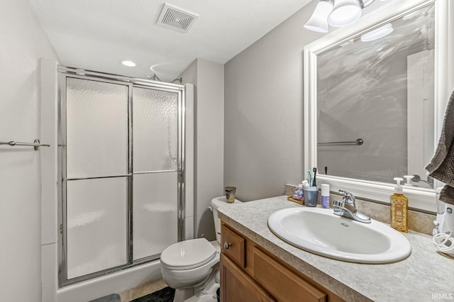 bathroom featuring a shower with door, toilet, and vanity