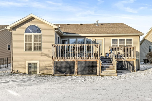 snow covered rear of property featuring a wooden deck and cooling unit