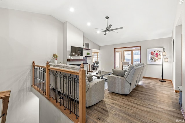 living room with lofted ceiling, ceiling fan, and light hardwood / wood-style flooring