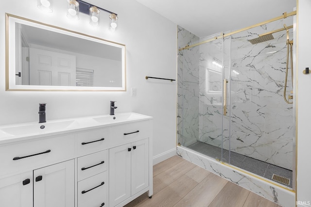 bathroom featuring a shower with door and vanity