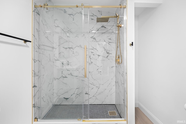 bathroom with hardwood / wood-style floors and an enclosed shower