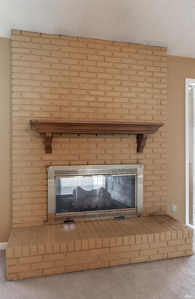 room details with a textured ceiling, carpet, and a fireplace