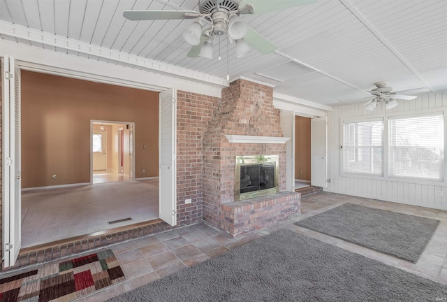 unfurnished living room featuring a brick fireplace and ceiling fan