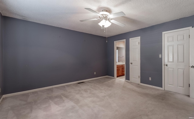 unfurnished bedroom featuring a textured ceiling, ceiling fan, and connected bathroom