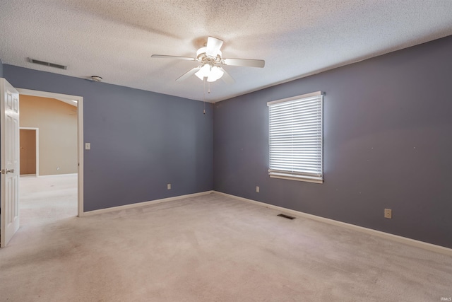 unfurnished room with ceiling fan, light carpet, and a textured ceiling