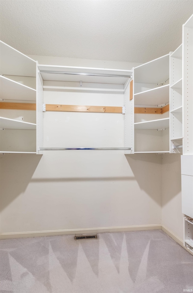 walk in closet featuring light carpet