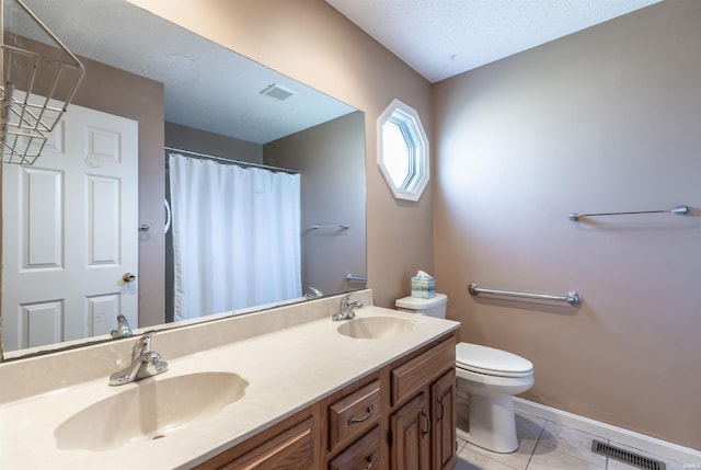 bathroom featuring toilet, vanity, tile patterned flooring, and a textured ceiling