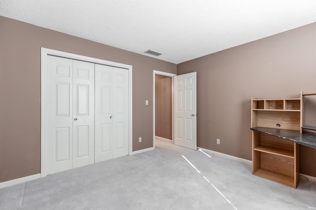 unfurnished bedroom with light colored carpet and a closet