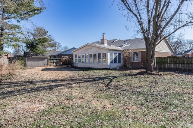 back of property with a yard and a storage unit