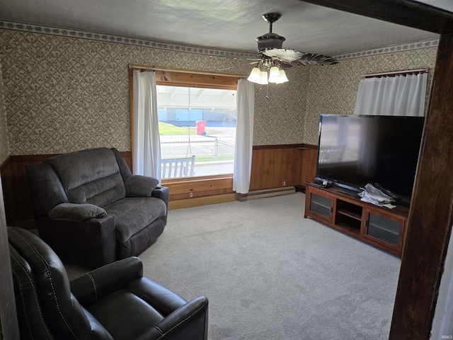 carpeted living room featuring ceiling fan and wooden walls