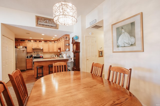 dining room featuring light wood-type flooring and a chandelier