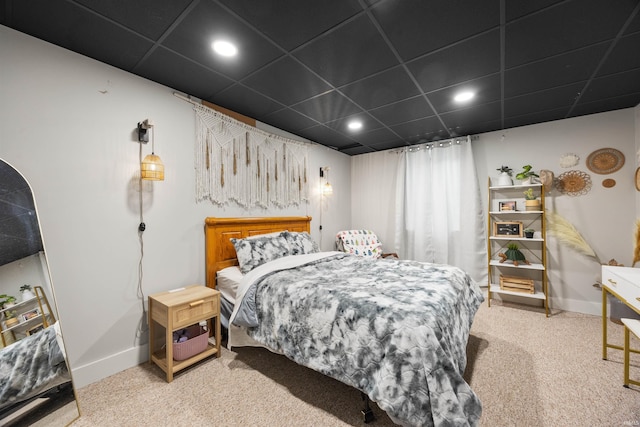 bedroom with light carpet and a drop ceiling