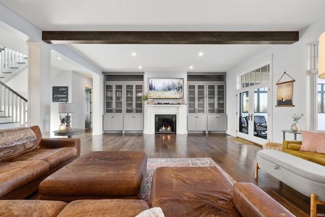 living room featuring beam ceiling, dark hardwood / wood-style floors, and decorative columns