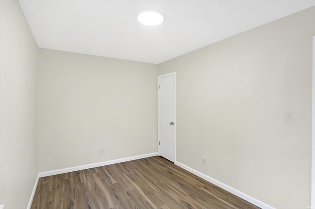 unfurnished room with dark wood-type flooring