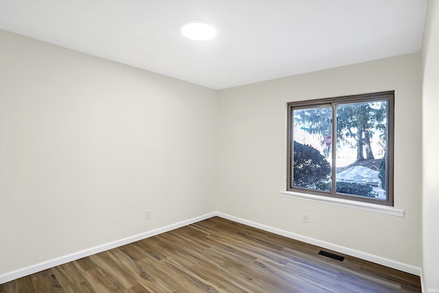 spare room with dark hardwood / wood-style flooring