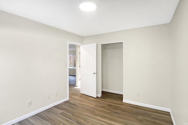 unfurnished bedroom featuring a closet and dark hardwood / wood-style flooring