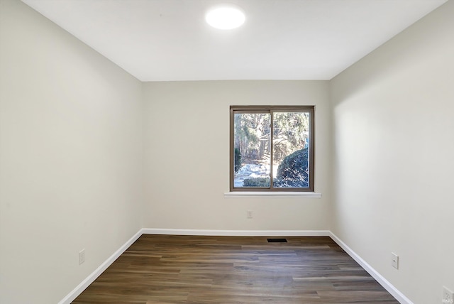 spare room featuring dark wood-type flooring