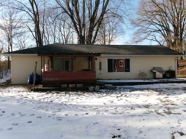 view of snow covered back of property